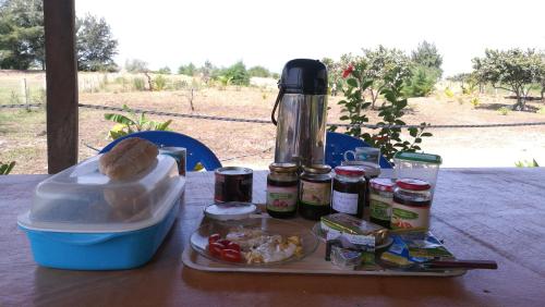 a table with a tray of food and a thermos at Le Papayer Écolodge in Boukot Ouolof