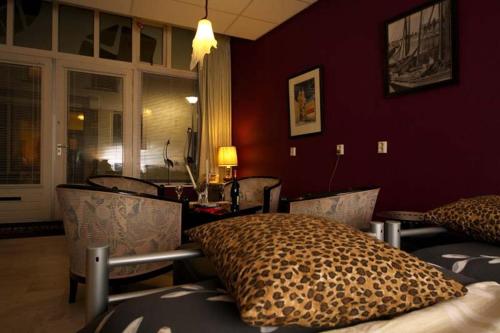 a bedroom with a leopard print bed and chairs at De Zilveren Karper in Kampen