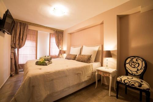 a bedroom with a large bed and a chair at Villa Aurelia Old Town in Kavala