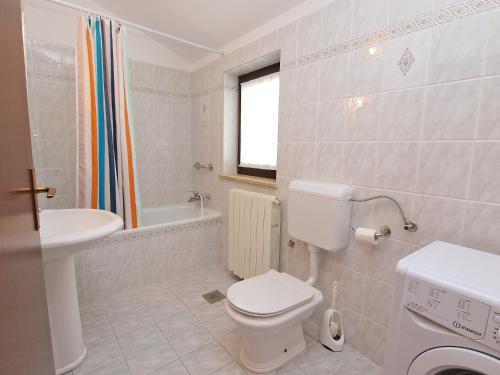 een witte badkamer met een toilet en een wastafel bij Apartments Slavica 590 in Fažana