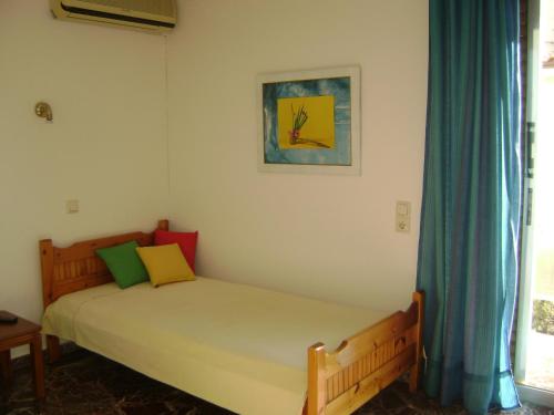 a bedroom with a bed and a painting on the wall at Avra in Artemida