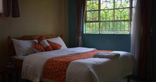 ein Bett mit einem Teddybär, der in einem Schlafzimmer darauf liegt in der Unterkunft Sheywe Hotel Kakamega in Kakamega