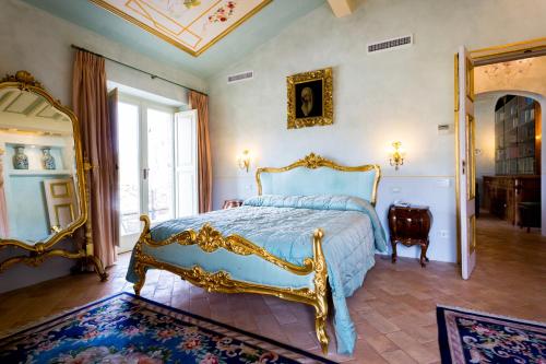 a bedroom with a blue bed and a mirror at Tenuta Del Gallo in Amelia