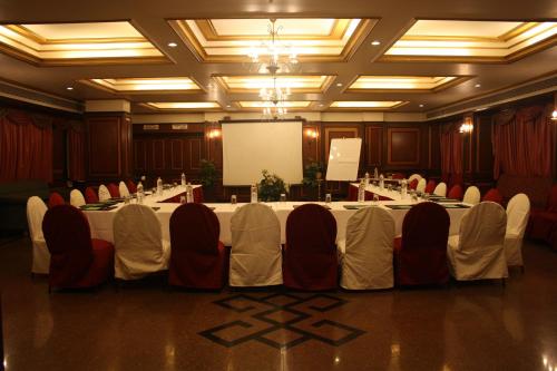 a conference room with a table with chairs and a screen at Hotel Karl Residency in Mumbai