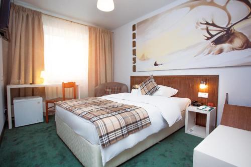 a hotel room with a bed and a large painting on the wall at Vostok Hotel in Tyumen