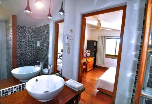 La salle de bains est pourvue de 2 lavabos et d'un grand miroir. dans l'établissement Rova Hotel, à Antananarivo