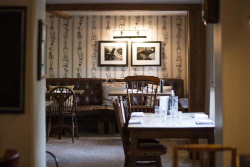 a dining room with a table and chairs and a couch at The Museum Inn in Farnham