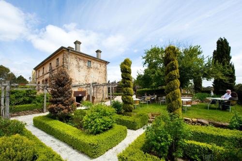 an old building with a garden in front of it at Mineral Springs Hotel Hepburn in Hepburn Springs