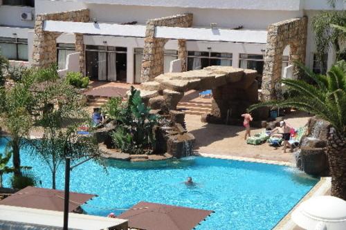 a swimming pool in a hotel with people in it at Melini Hotel Suites in Protaras