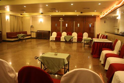a conference room with tables and chairs and a stage at Hotel Karl Residency in Mumbai