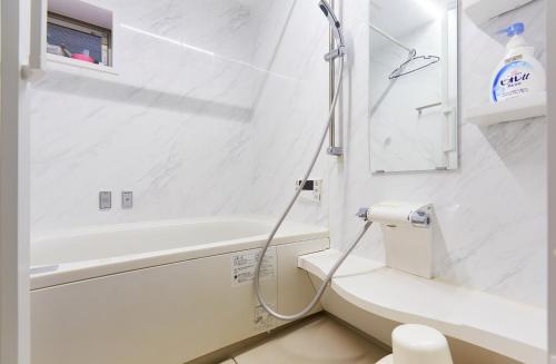 uma casa de banho branca com um chuveiro e um WC. em Haneda Luxury House em Tóquio