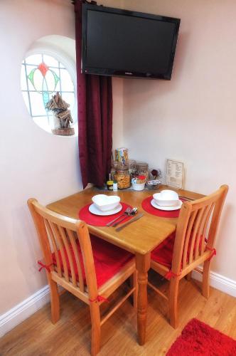 a dining room table with two chairs and a television at Heathfield Bed and Breakfast in Whitby