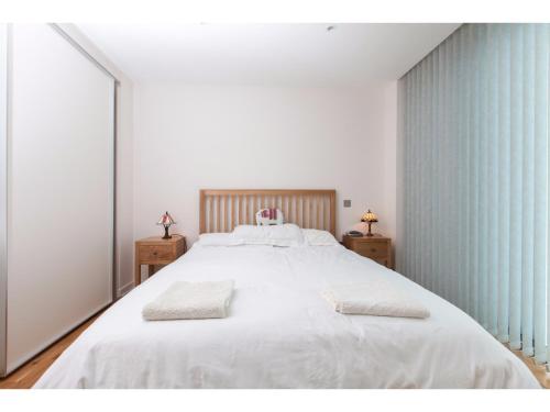 エディンバラにあるElegant & Modern Apartment in Central Edinburghのベッドルーム1室(白い大型ベッド1台、ナイトスタンド2台付)