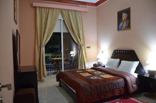a bedroom with a large bed and a balcony at Almounia Hotel & Spa in Taroudant