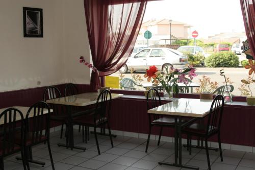 une salle à manger avec des tables et des chaises ainsi qu'une fenêtre dans l'établissement Hotel de l'Avenue, à Bonson