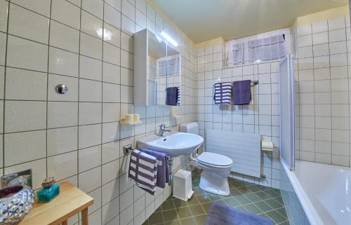 a bathroom with a sink and a toilet and a tub at Appartement Rainer in Saalbach-Hinterglemm