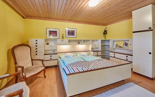 a bedroom with a bed and a chair at Appartement Rainer in Saalbach-Hinterglemm