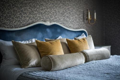 a bed with a blue headboard and pillows on it at The Spa Hotel in Royal Tunbridge Wells