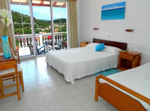 a hotel room with two beds and a balcony at Niko's Studio Apartments with terrace in Gaios