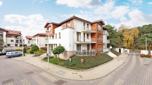 un edificio de apartamentos con un coche aparcado delante de él en Dom & House - Apartamenty Neptun Park, en Gdansk
