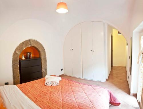 ナポリにあるNapul'é Apartamentのベッドルーム1室(大型ベッド1台、アーチ型の入り口付)