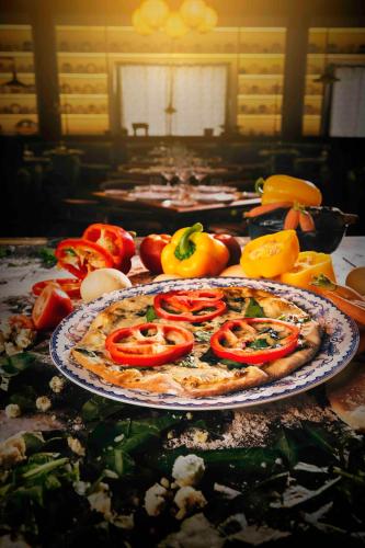 a table topped with a pizza with tomatoes and other vegetables at Unico Hotel Riviera Maya Adults Only in Akumal