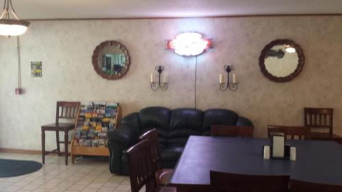 a waiting room with a leather couch and tables and mirrors at Audrey's Motel in Mound City