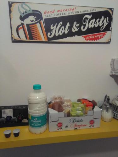 een plank met een fles hete saus en een doos met eten bij Bed & Breakfast Anzola in Anzola dell'Emilia