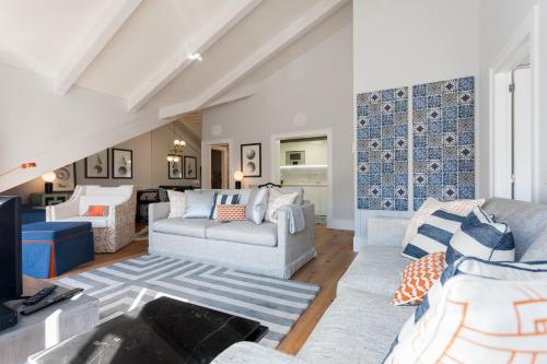 a living room with two couches and a tv at FLH Restauradores Amazing Flat with View in Lisbon