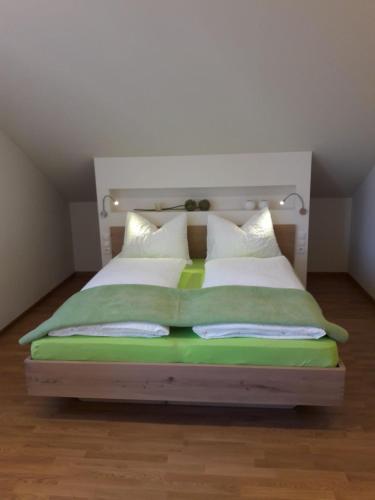 a bedroom with a bed with green and white pillows at Versigglhof in Appiano sulla Strada del Vino