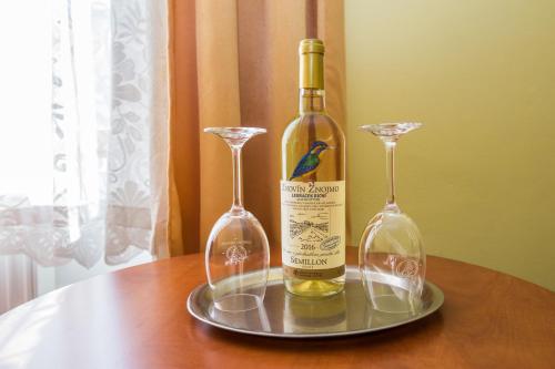a bottle of wine and two glasses on a table at Hotel Morava in Znojmo
