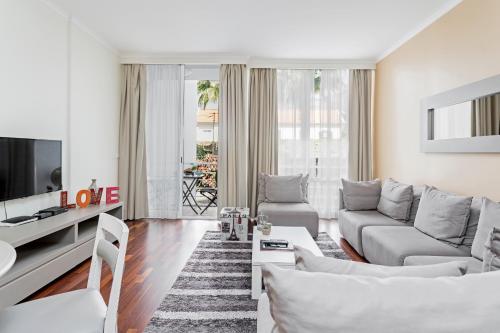 a living room with a couch and a tv at Achada I by An Island Apart in Funchal