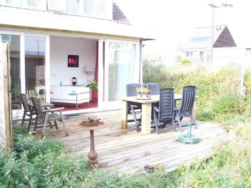 a patio with chairs and a table on a deck at Appartementen Bergen aan Zee de Schelp in Bergen aan Zee