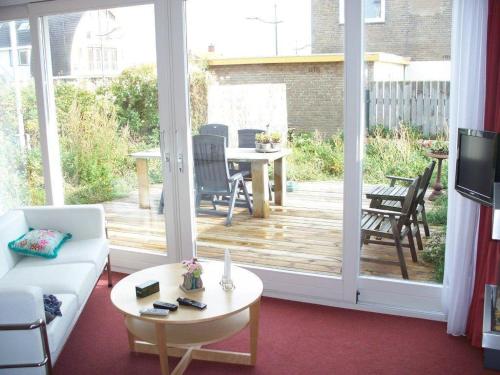 una sala de estar con una gran puerta corredera de cristal en Appartementen Bergen aan Zee de Schelp, en Bergen aan Zee