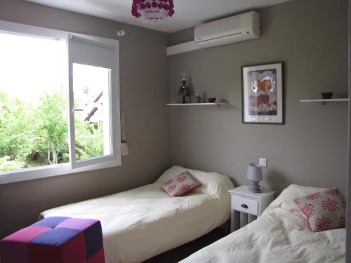 1 Schlafzimmer mit 2 Betten und einem Fenster in der Unterkunft Gîte "Au Gré de l'Adour" in Aire-sur-lʼAdour