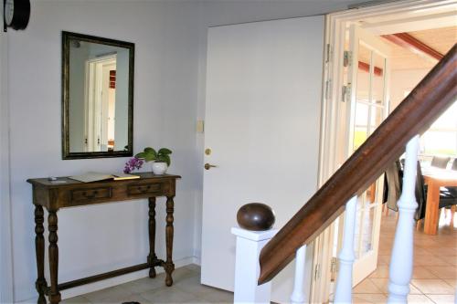 a hallway with a table and a mirror on a wall at Rødkærgård Bed & Breakfast in Kerteminde