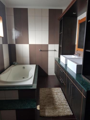 un baño con bañera y lavabo en Deluxe Home Praia do Populo, en Cabouco