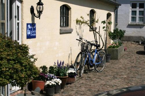 a bike parked next to a building with flowers at Rødkærgård Bed & Breakfast in Kerteminde