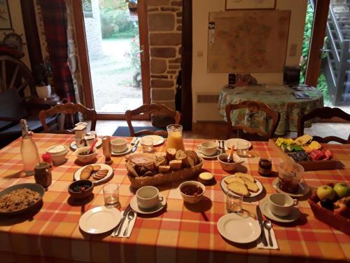 a table with food on a checkered table cloth at Les Pieds dans l'Herbe in Rosporden