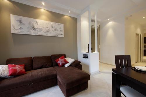 a living room with a brown couch and a table at Apartment with parking in Nice near the harbor in Nice