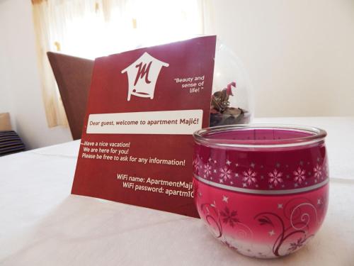 una taza roja sentada en una mesa junto a una caja en Apartments Majić, en Vinišće