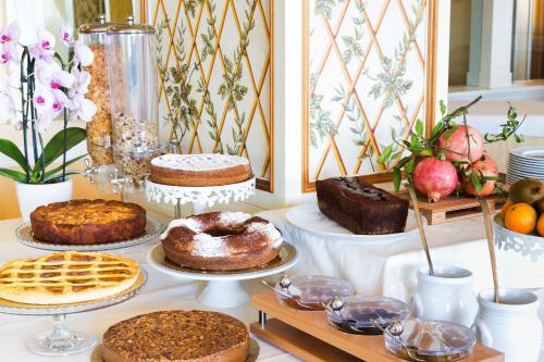 a table topped with cakes and other desserts on plates at Hotel Tuder in Todi