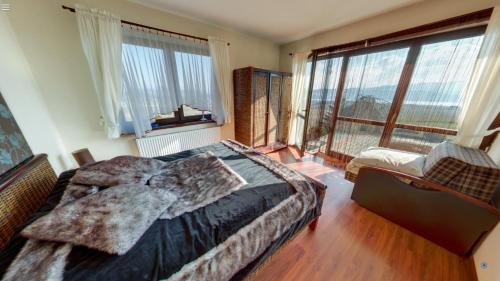 a bedroom with a bed and a large window at Villa Mango in Maniowy