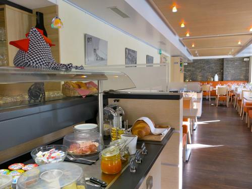 a restaurant with a counter with food on it at Boutique und Bier Hotel des alpes in Fiesch