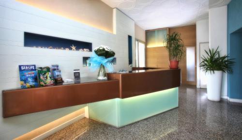 a lobby with a reception desk with a blue bow at Hotel Dante in Lido di Jesolo