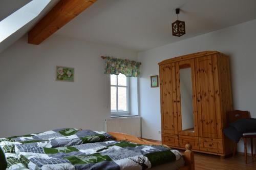 1 dormitorio con 1 cama y armario de madera en Ferienwohnung Jäger, en Grebenstein