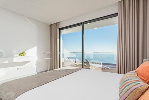 a bedroom with a bed and a view of the ocean at Searenity Vacation Home I by An Island Apart in Arco da Calheta