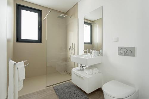 a white bathroom with a sink and a toilet at Searenity Vacation Home I by An Island Apart in Arco da Calheta