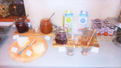 un comptoir avec des pots de confiture et des verres de liquide dans l'établissement Hotel Lo Scudiero, à Turin