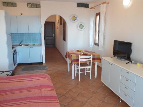 cocina y comedor con mesa y TV en Splendido mono vista mare con wi fi a 100 mt da spiaggia, en Santa Teresa Gallura